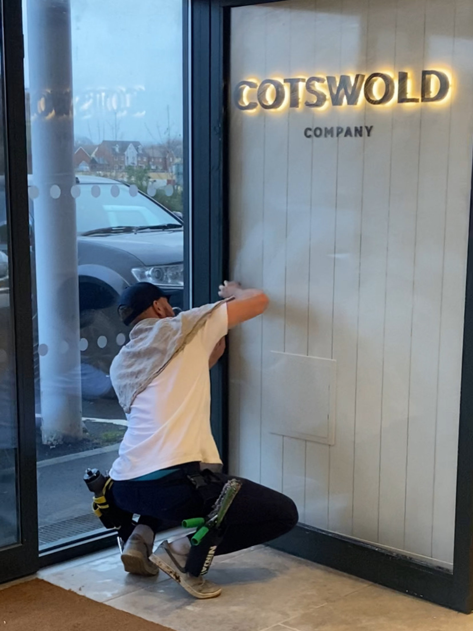Cleaning the glass shopfront of the Cotswold Company store
